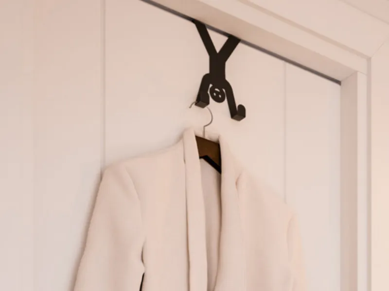 Percha de Ducasse colgada de una puerta, con una bata